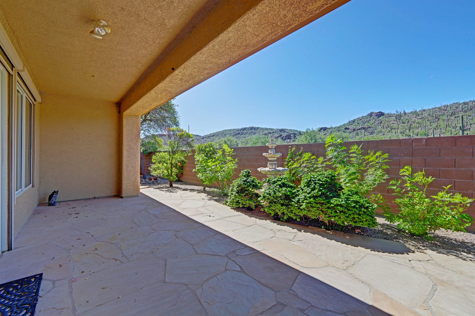 Covered patio and desert landscaping with mountain views